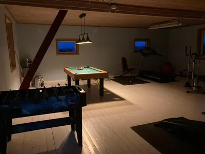 a room with a pool table in the middle of a room at Rødseth Gårdsovernatting Familierom in Molde