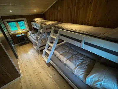 a room with three bunk beds in a cabin at Stall-loftet, Aastrøen gård, Vingelen in Vingelen