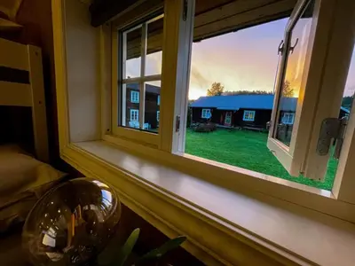 a window in a room with a view of a house at Stall-loftet, Aastrøen gård, Vingelen in Vingelen