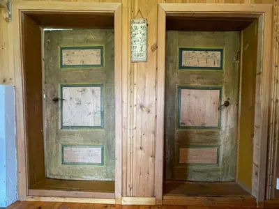 two doors in a room with wooden walls at Gammelstua ved Femund in Elga