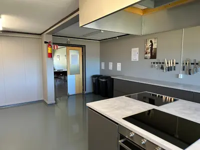 a large kitchen with a counter top and a room at Karivollen Overnatting in Melhus