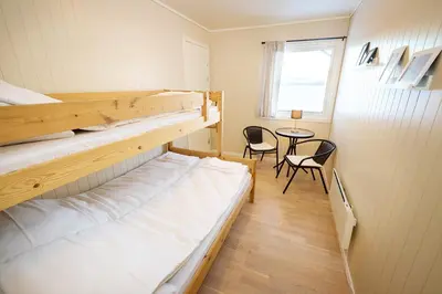 a room with two bunk beds and a table at Karivollen Overnatting in Melhus