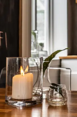 a candle in two glass vases on a table at Cozy apartment in Alesund city in Ålesund