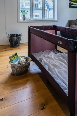 a bed with a basket of books and a stuffed animal at Cozy apartment in Alesund city in Ålesund