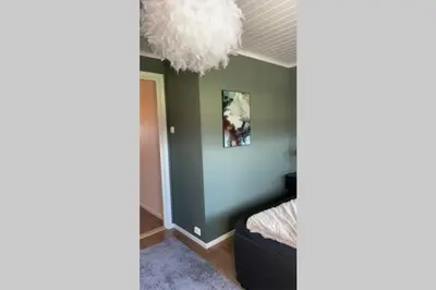 a room with a bed and a chandelier at Townhouse with fantastic outdoor area in Trondheim
