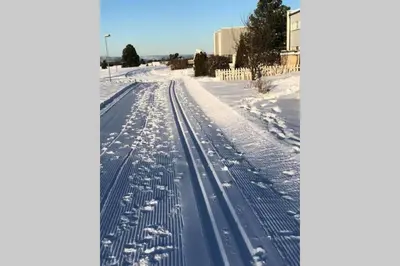 a snow covered road with tracks in the snow at Townhouse with fantastic outdoor area in Trondheim