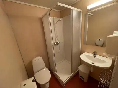 a bathroom with a shower and a toilet and a sink at Gjøa Motell in Rosendal
