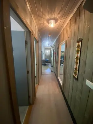 a hallway in a house with wood walls and a ceiling at Kvamseter Lodge private family apartment in Kvam