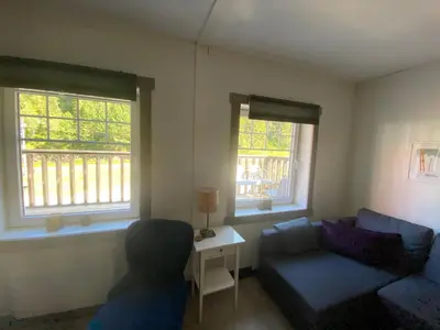 a living room with a couch and two windows at Kvamseter Lodge private family apartment in Kvam