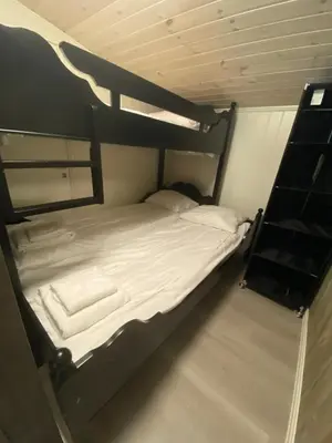 a bedroom with a bunk bed with white sheets at Kvamseter Lodge private family apartment in Kvam