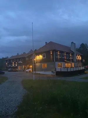 a building with lights on in a parking lot at Kvamseter Lodge private family apartment in Kvam