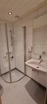 a bathroom with a shower and a sink at Raubergstulen fjellstue og hytter in Boverdalen