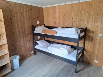 two bunk beds in a room with wooden walls at Raubergstulen fjellstue og hytter in Boverdalen