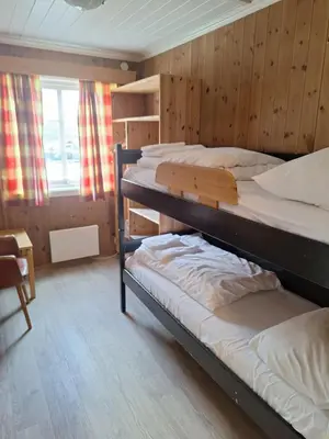 two bunk beds in a room with wooden walls at Raubergstulen fjellstue og hytter in Boverdalen