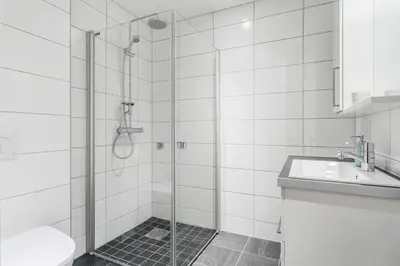 a bathroom with a shower with a sink and a toilet at Totally independent apartment near NTNU,Lerkendal and Center in Trondheim