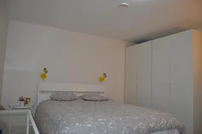 a bedroom with a bed and a white wall at Totally independent apartment near NTNU,Lerkendal and Center in Trondheim