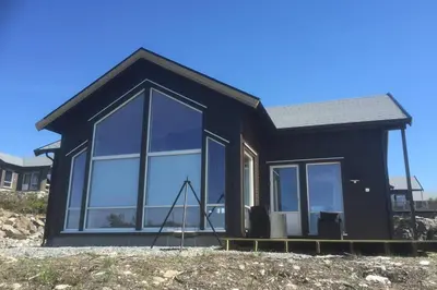 a small black house with large windows at Austefjordtunet 15 in Forland