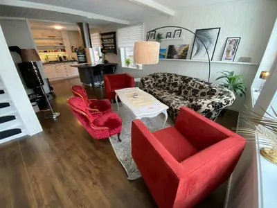 a living room with red chairs and a table at Villa Rjukan in Rjukan
