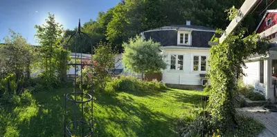 a backyard with a white house and a yard at Villa Rjukan in Rjukan