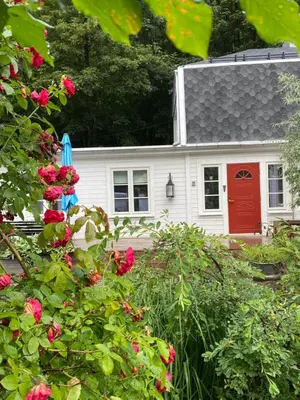 a white house with a red door and some roses at Villa Rjukan in Rjukan