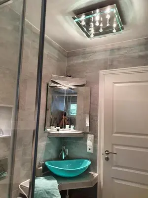 a bathroom with a blue sink and a mirror at Småstranda Fjord Lodge in Åheim