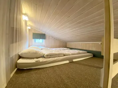 a large bed in a room with a ceiling at Vennebo - Koselig liten hytte med alle fasiliteter in Ål