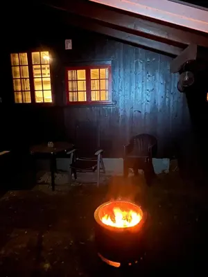 a fire pit in front of a house at night at Vennebo - Koselig liten hytte med alle fasiliteter in Ål