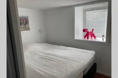 a bedroom with a bed with a red dog in a window at Kjellerleilighet - nært Haukeland sykehus. in Bergen