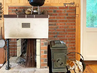 a brick fireplace with a stove and a grill at 4 person holiday home in Reksteren-By Traum in Klinkholmen
