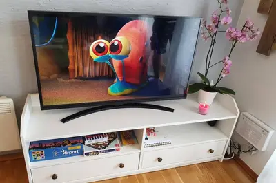 a tv sitting on top of a white entertainment center at Fantastic and high standard apartment in Nordseter in Lillehammer