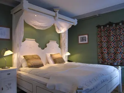 a bedroom with a white bed with a canopy at Hjelle Hotel in Hjelle