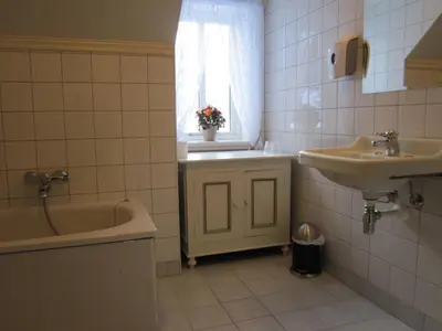 a bathroom with a sink and a tub and a window at Hjelle Hotel in Hjelle