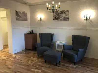 a waiting room with two chairs and a table at Hjelle Hotel in Hjelle