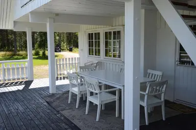 a porch with a table and chairs on a house at Fulufjellet nationalpark Lodge - Home of snow, nature and peace in Ljørdalen