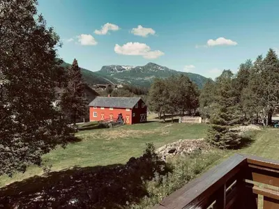 a red barn in the middle of a field at Super sentral, flott og solrik leilighet i sentrum in Hemsedal