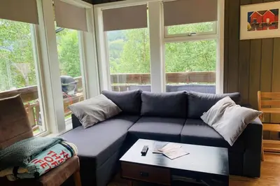a living room with a blue couch and a table at Super sentral, flott og solrik leilighet i sentrum in Hemsedal