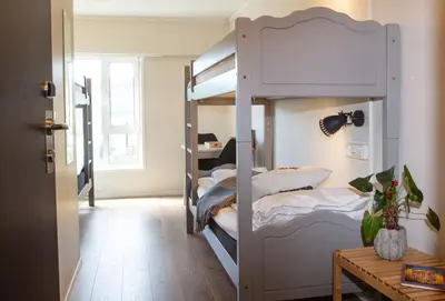 a room with bunk beds and a table at Lillehammer Hostel in Lillehammer