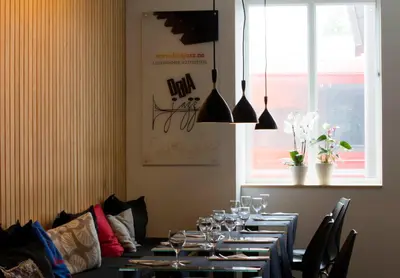 a dining room with a long table with wine glasses at Lillehammer Hostel in Lillehammer