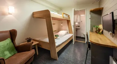 a small room with a bunk bed and a chair at Hamar Vandrerhjem in Hamar