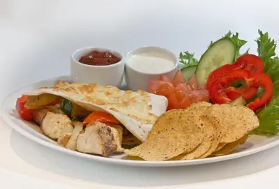 a plate of food with a sandwich and chips and vegetables at Hamar Vandrerhjem in Hamar