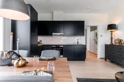 a kitchen and living room with black cabinets and a table at MJOS TOWER Apartment - Lovely city view in Ringsaker