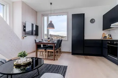 a kitchen and living room with a table and a dining room at MJOS TOWER Apartment - Lovely city view in Ringsaker