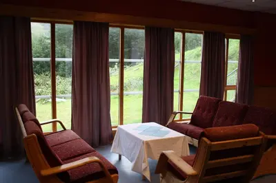 a living room with a couch and chairs and a table at Dovreskogen Gjestegård AS in Dovreskogen