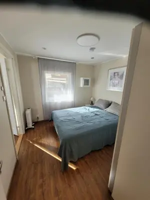 a bedroom with a bed in a room with wooden floors at Espeland in Bergen