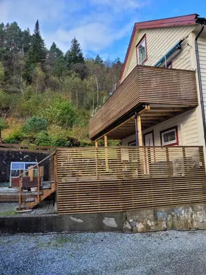 a house with a wooden fence in front of it at Espeland in Bergen