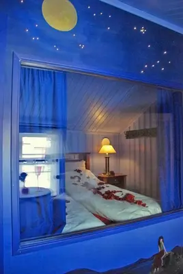 a room with a large window with a bed in it at Regnbuegården in Røros