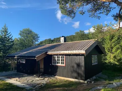 a black shed with a gambrel roof at Fjellro Mountain Cabin in Oppdal