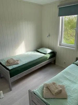 a bedroom with two beds and a window at Feriehus med Sjøutsikt in Sætra
