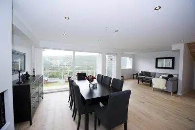 a dining room and living room with a table and chairs at Ustedalen Resort Leiligheter in Geilo