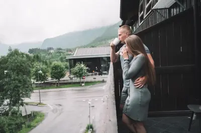 a man and a woman are standing on a ledge at Skiers Lodge 2 - Saga Apartments in Hemsedal